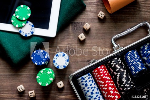 Picture of Pocker set in a metallic case nearby tablet on a wooden table top view
